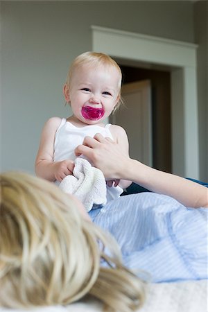 family tickling - woman lying on a bed with her baby girl Stock Photo - Premium Royalty-Free, Code: 640-02949795