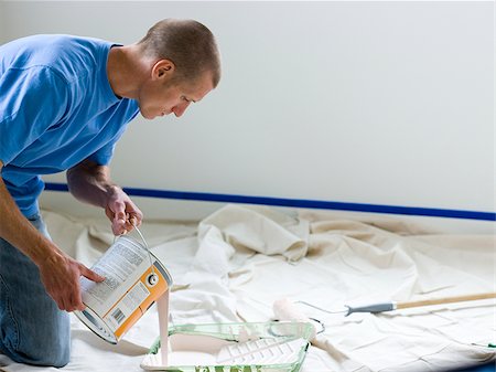 man pouring paint into a roller tray Foto de stock - Sin royalties Premium, Código: 640-02949884