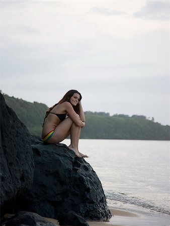 simsearch:640-02947668,k - woman in a bikini sitting on the rocks at the beach Stock Photo - Premium Royalty-Free, Code: 640-02949897