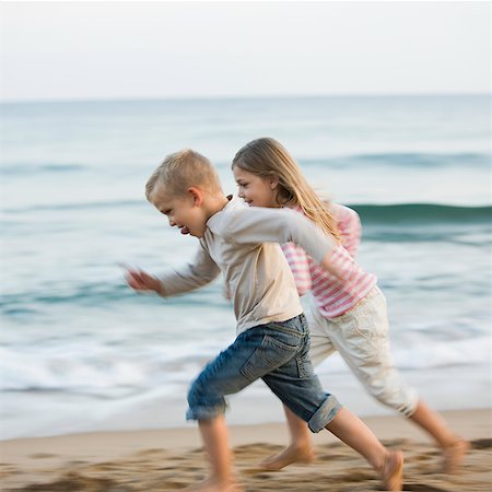 brother and sister running at the beach Stock Photo - Premium Royalty-Free, Code: 640-02950147