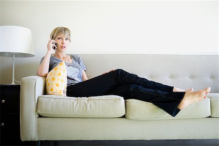 phone young caucasian woman relaxed - woman on the couch using cell phone Stock Photo - Premium Royalty-Free, Code: 640-02950169