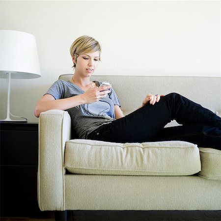 simsearch:640-08089386,k - woman on the couch using cell phone Stock Photo - Premium Royalty-Free, Code: 640-02950171
