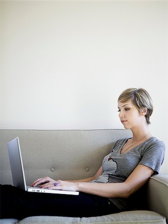 simsearch:640-03257126,k - woman on the couch using a laptop Fotografie stock - Premium Royalty-Free, Codice: 640-02950204