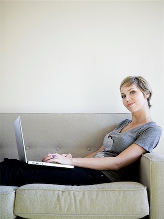 simsearch:640-03257126,k - woman on the couch using a laptop Fotografie stock - Premium Royalty-Free, Codice: 640-02950205