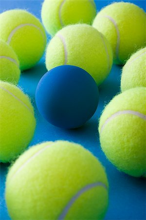 palla da tennis - tennis balls and a racquetball against a blue background Fotografie stock - Premium Royalty-Free, Codice: 640-02950259