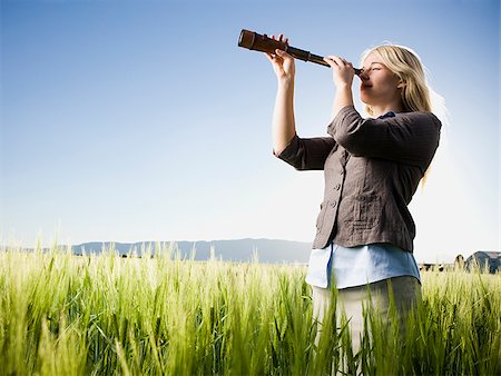 person with telescope - businesswoman holding a spyglass telescope Stock Photo - Premium Royalty-Free, Code: 640-02950477