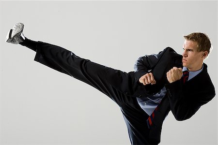 businessman doing a karate kick Stock Photo - Premium Royalty-Free, Code: 640-02950511