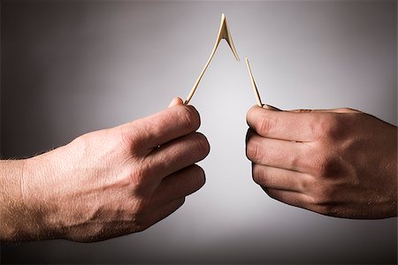 two hands breaking a wishbone Stock Photo - Premium Royalty-Free, Code: 640-02950611