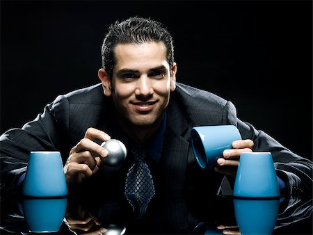 businessman playing the cup game Stock Photo - Premium Royalty-Free, Code: 640-02950907