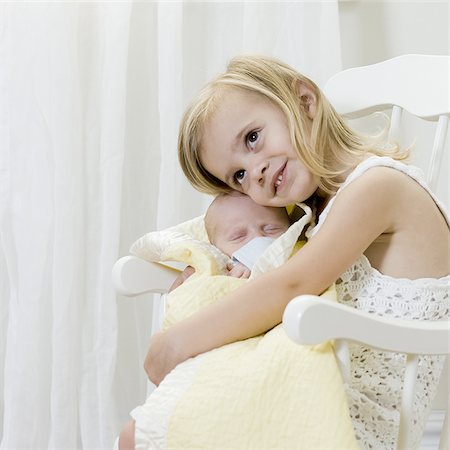 sister hugs baby - big sister holding her newborn brother Stock Photo - Premium Royalty-Free, Code: 640-02951219