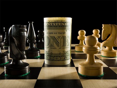 rolled currency on a chess board Stock Photo - Premium Royalty-Free, Code: 640-02951813