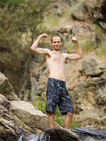 man flexing above a rock waterslide Stock Photo - Premium Royalty-Free, Code: 640-02951825