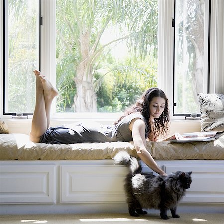 woman on a window bench with her cat Stock Photo - Premium Royalty-Free, Code: 640-02951895