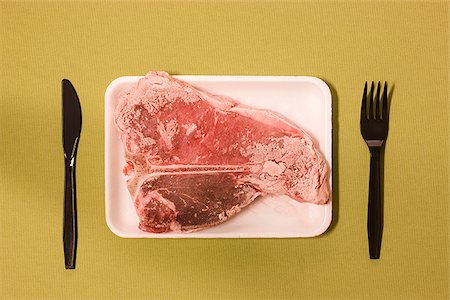 steak fork - frozen uncooked steak being served on a plate Stock Photo - Premium Royalty-Free, Code: 640-02952164