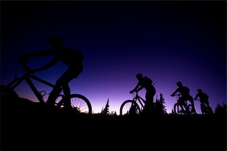 four mountain bikers in a row at dusk Foto de stock - Sin royalties Premium, Código: 640-02952193