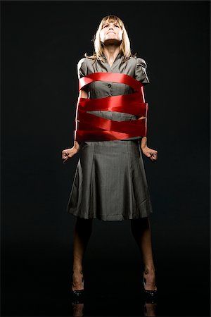 people tied up - businesswoman all wrapped up in red ribbon Foto de stock - Sin royalties Premium, Código: 640-02952215