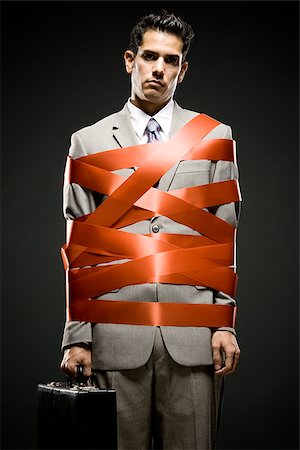 businessman wrapped up with red tape Foto de stock - Sin royalties Premium, Código: 640-02952287