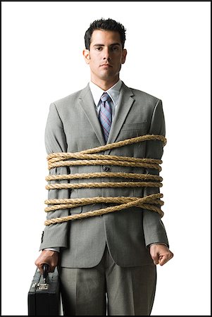 businessman in a full suit tied up with a rope around his mid section Stock Photo - Premium Royalty-Free, Code: 640-02952306