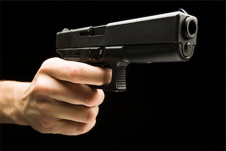 person hand on gun - glock handgun Stock Photo - Premium Royalty-Free, Code: 640-02952338