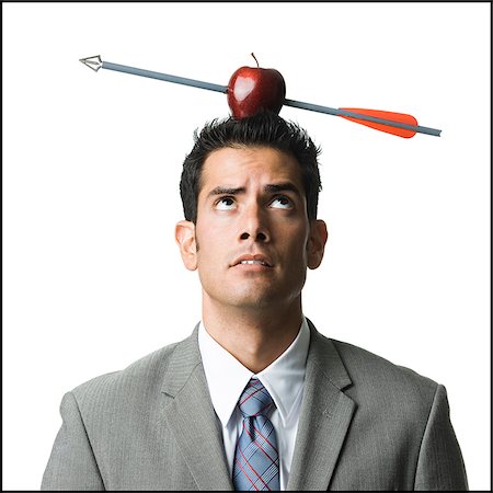 businessman with an apple on his head that has been shot with an arrow Stock Photo - Premium Royalty-Free, Code: 640-02952330