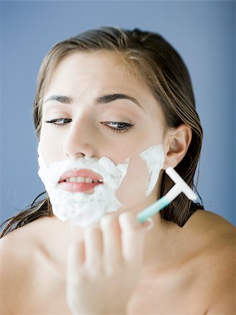 woman shaving her face with a razor and shaving cream Stock Photo - Premium Royalty-Free, Code: 640-02952415