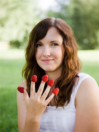 raspberry fingers - young woman eating a berry from each finger Stock Photo - Premium Royalty-Free, Code: 640-02952702
