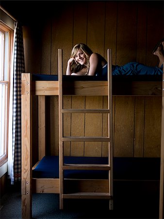 woman lying on the top bunk of a bunk bed Fotografie stock - Premium Royalty-Free, Codice: 640-02953014