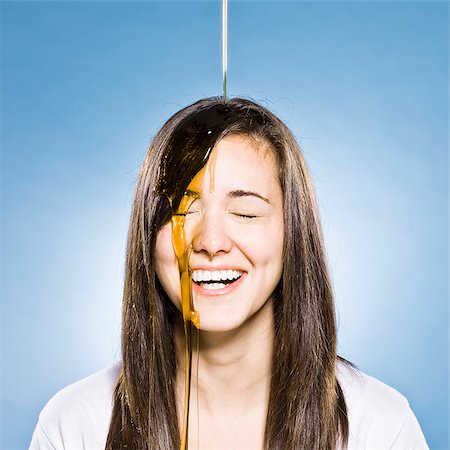 young woman with honey pouring down onto her head and face Foto de stock - Sin royalties Premium, Código: 640-02953047