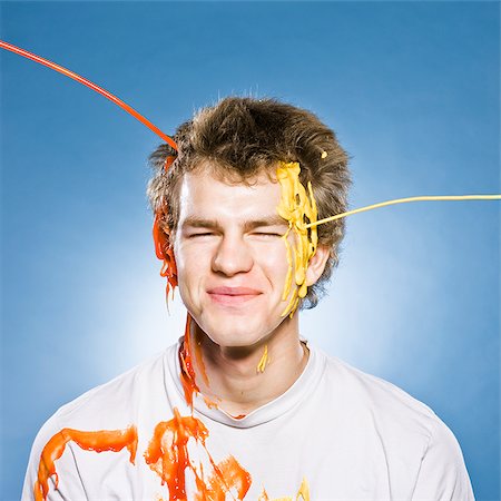 man getting ketchup and mustard poured on the head Foto de stock - Royalty Free Premium, Número: 640-02953105
