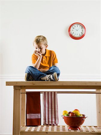 sitting sad boy - boy sitting on a kitchen table Stock Photo - Premium Royalty-Free, Code: 640-02953295