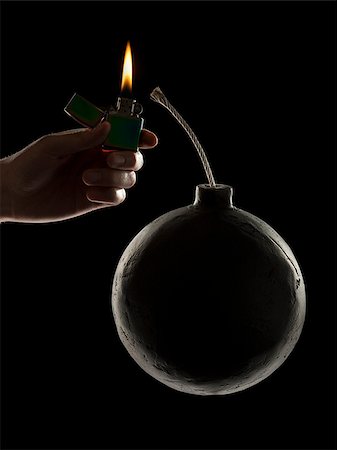 hand lighting the wick on a bomb Foto de stock - Sin royalties Premium, Código: 640-02953388