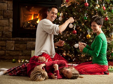 family and christmas and four people - family decorating their christmas tree Stock Photo - Premium Royalty-Free, Code: 640-02953382