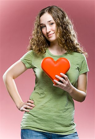 woman holding a heart to her chest Stock Photo - Premium Royalty-Free, Code: 640-02953398