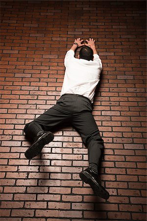 man climbing up a brick wall Foto de stock - Royalty Free Premium, Número: 640-02953430