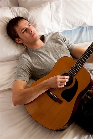 homme couché dans son lit avec sa guitare Photographie de stock - Premium Libres de Droits, Code: 640-02953432