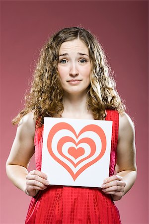 scared young woman one not man not asian - woman holding a red heart over her chest Stock Photo - Premium Royalty-Free, Code: 640-02953450