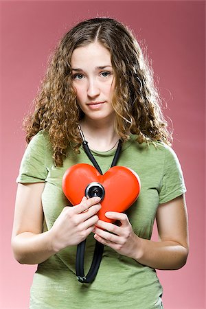 stethoscope, heart - femme tenant un stéthoscope jusqu'à son coeur Photographie de stock - Premium Libres de Droits, Code: 640-02953477