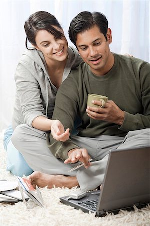 Man and woman on carpet with laptops Stock Photo - Premium Royalty-Free, Code: 640-03255777