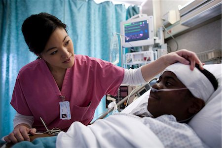 Nurse talking with boy in hospital bed Stock Photo - Premium Royalty-Free, Code: 640-03255831