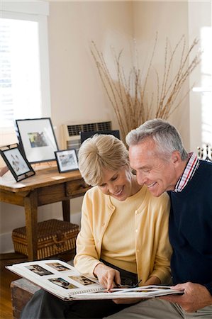 Mature couple looking at photo album Stock Photo - Premium Royalty-Free, Code: 640-03255855