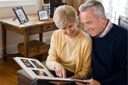 Mature couple looking at photo album Stock Photo - Premium Royalty-Free, Code: 640-03255851