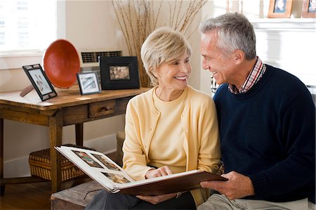 Mature couple looking at photo album Stock Photo - Premium Royalty-Free, Code: 640-03255852