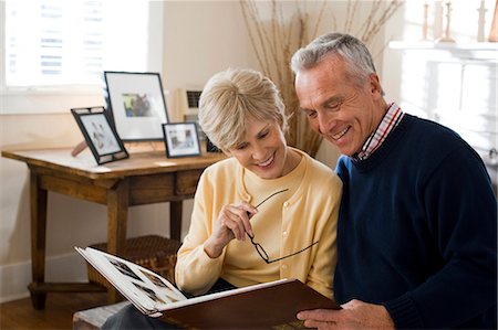 Mature couple looking at photo album Stock Photo - Premium Royalty-Free, Code: 640-03255853