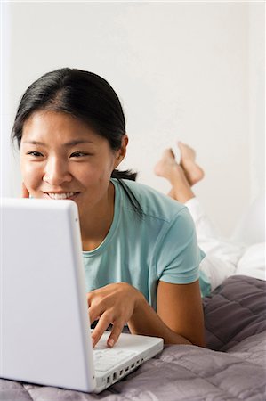 Woman on bed with laptop Stock Photo - Premium Royalty-Free, Code: 640-03255909