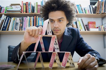pyramide - Homme faisant une pyramide de cartes à jouer Photographie de stock - Premium Libres de Droits, Code: 640-03256015