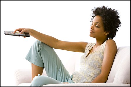 Woman with a remote control Stock Photo - Premium Royalty-Free, Code: 640-03256046