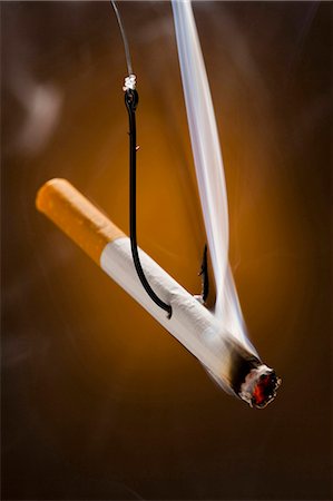 smoker - Cigarette with a fish hook through it Foto de stock - Sin royalties Premium, Código: 640-03256053