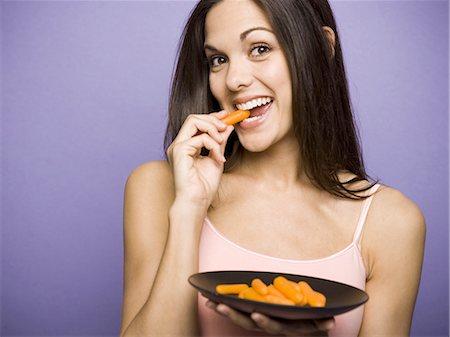 Woman eating carrot sticks Stock Photo - Premium Royalty-Free, Code: 640-03256250