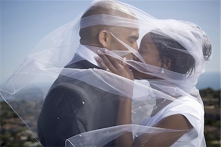 Profile of a newlywed couple kissing each other under a veil Stock Photo - Premium Royalty-Free, Code: 640-03256323