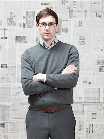 Portrait of young man standing in newspaper room Stock Photo - Premium Royalty-Free, Code: 640-03256386